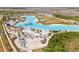 Aerial view of a community lagoon surrounded by sand, buildings, and palm trees at 8946 Ivy Stark Blvd, Wesley Chapel, FL 33545