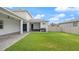 A well-maintained backyard features a green lawn and a covered patio for outdoor living at 8946 Ivy Stark Blvd, Wesley Chapel, FL 33545