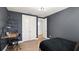 Dark painted bedroom featuring a comfortable bed, a functional desk and closet at 8946 Ivy Stark Blvd, Wesley Chapel, FL 33545