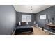 Modern bedroom with dark gray walls, desk, white board, and wood-look floors at 8946 Ivy Stark Blvd, Wesley Chapel, FL 33545