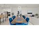Bright dining area features blue velvet chairs and access to the kitchen and living room at 8946 Ivy Stark Blvd, Wesley Chapel, FL 33545