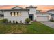 Charming two-story home with landscaped yard, brick driveway, and attached two-car garage at 8946 Ivy Stark Blvd, Wesley Chapel, FL 33545