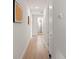 Light-filled hallway with hardwood floors and decorative wall art leading to the rest of the house at 8946 Ivy Stark Blvd, Wesley Chapel, FL 33545
