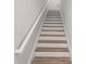 Wooden staircase with white risers and white banister at 8946 Ivy Stark Blvd, Wesley Chapel, FL 33545