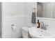 Bathroom with white wainscoting, pedestal sink, and classic fixtures, offers a clean, timeless look at 930 23Rd N Ave, St Petersburg, FL 33704