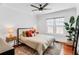 Bedroom with hardwood floors, a ceiling fan, large window, and a bed dressed with decorative pillows at 930 23Rd N Ave, St Petersburg, FL 33704