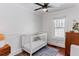 Bedroom features a white crib, wood floors, a ceiling fan, and a window providing natural light at 930 23Rd N Ave, St Petersburg, FL 33704