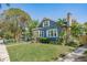 Charming two-story home showcasing manicured lawn, lush landscaping, and inviting blue exterior at 930 23Rd N Ave, St Petersburg, FL 33704