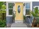 A bright yellow front door flanked by matching planters and stylish outdoor lanterns at 930 23Rd N Ave, St Petersburg, FL 33704
