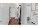 Hallway with hardwood floors leads to a bathroom with classic fixtures at 930 23Rd N Ave, St Petersburg, FL 33704