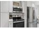 Modern kitchen with stainless steel microwave, oven, and refrigerator and ample cabinet space at 930 23Rd N Ave, St Petersburg, FL 33704
