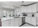 Bright kitchen features white cabinets, stainless steel appliances, marble countertops, and a view into the dining area at 930 23Rd N Ave, St Petersburg, FL 33704