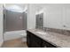 Bathroom featuring a granite countertop, dark vanity, and tiled shower at 930 57Th N Ave, St Petersburg, FL 33703