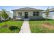 Charming single-story home showcasing a well-manicured lawn and inviting front porch with stone accents at 930 57Th N Ave, St Petersburg, FL 33703