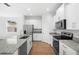 Modern kitchen features white cabinets, granite countertops, stainless steel appliances, and a window at 930 57Th N Ave, St Petersburg, FL 33703