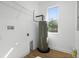 Utility room with a water heater, wood-look flooring and a window at 930 57Th N Ave, St Petersburg, FL 33703