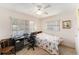 Cozy bedroom featuring a floral comforter, ceiling fan, a window with blinds, and a working desk at 9740 45Th N St, Pinellas Park, FL 33782