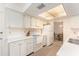 Bright kitchen with white cabinets, appliances, and a view to the dining area at 9740 45Th N St, Pinellas Park, FL 33782