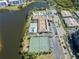 Aerial view of the community pool, clubhouse, tennis courts, lake, and residential buildings at 10035 63Rd N Ave # 12, St Petersburg, FL 33708
