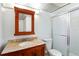 Bathroom features a granite vanity, a wood framed mirror, a toilet, and a glass enclosed shower at 10035 63Rd N Ave # 12, St Petersburg, FL 33708