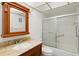 Bathroom features a granite vanity, a wood framed mirror, a toilet, and a glass enclosed shower at 10035 63Rd N Ave # 12, St Petersburg, FL 33708