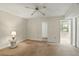 Bright bedroom with a ceiling fan, neutral walls, and doorways leading to bathroom and outdoor balcony at 10035 63Rd N Ave # 12, St Petersburg, FL 33708