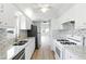 Galley kitchen featuring stainless steel appliances, mosaic backsplash, and granite countertops at 10035 63Rd N Ave # 12, St Petersburg, FL 33708