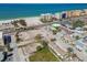 Community aerial view with charming cottage-style homes, sunny beach, and busy street at 103 146Th E Ave, Madeira Beach, FL 33708