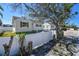 Exterior shot showcasing a charming home with a white picket fence and well-maintained landscaping at 103 146Th E Ave, Madeira Beach, FL 33708