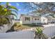 Exterior showcases a charming house with a fenced yard and tropical foliage at 103 146Th E Ave, Madeira Beach, FL 33708