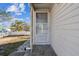 Close-up of a home's front porch with a screen door and neutral siding, enhancing the entrance at 103 146Th E Ave, Madeira Beach, FL 33708