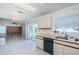 Bright and airy kitchen with white cabinets and appliances, a sliding glass door, and an open view to the living room at 10906 Kenbrook Dr, Riverview, FL 33578