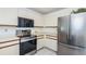 Functional kitchen with stainless steel appliances, including a range, microwave, and refrigerator, offering modern convenience at 10906 Kenbrook Dr, Riverview, FL 33578