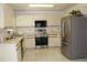 Modern kitchen featuring stainless steel appliances, white cabinetry, and tile flooring at 10906 Kenbrook Dr, Riverview, FL 33578