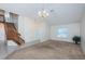 Spacious living room with staircase, neutral color palette, chandelier, and ample natural light at 10906 Kenbrook Dr, Riverview, FL 33578
