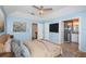 A large bedroom with blue walls, ceiling fan, and ensuite bathroom access at 10906 Kenbrook Dr, Riverview, FL 33578