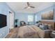 Serene main bedroom with blue walls, plush bedding, and a ceiling fan, offering a peaceful retreat at 10906 Kenbrook Dr, Riverview, FL 33578