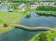 Scenic aerial view of wooden bridge across a tranquil lake, showcasing the neighborhood and pond at 11147 Brambleleaf Way, Hudson, FL 34667
