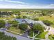 Community clubhouse and golf course aerial view featuring lush green landscapes and a tranquil pond at 11147 Brambleleaf Way, Hudson, FL 34667