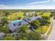 Stunning aerial view of the community clubhouse, golf course and surrounding greenery in a beautiful sunny setting at 11147 Brambleleaf Way, Hudson, FL 34667