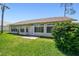 Backyard view showcasing a lush lawn, mature tree, and home exterior, perfect for outdoor living at 11147 Brambleleaf Way, Hudson, FL 34667