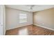 Bedroom featuring hardwood floors, ceiling fan, and a window providing natural light at 11147 Brambleleaf Way, Hudson, FL 34667