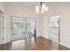 Bright dining room featuring hardwood floors with a sliding glass door leading to the lanai and kitchen at 11147 Brambleleaf Way, Hudson, FL 34667