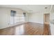 Bright living room showcases wood floors, large window with curtains, and neutral wall color at 11147 Brambleleaf Way, Hudson, FL 34667