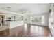 Open-concept living room with wood floors and a kitchen with granite countertops at 11147 Brambleleaf Way, Hudson, FL 34667