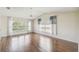 Spacious living room featuring wood floors, large windows, and ample natural light at 11147 Brambleleaf Way, Hudson, FL 34667