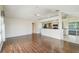 Bright and airy living room featuring wood floors, ceiling fan, and open layout to kitchen and screened-in patio at 11147 Brambleleaf Way, Hudson, FL 34667