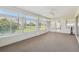 Open sunroom featuring large windows, ceiling fan, and neutral carpeting, perfect for relaxation at 11147 Brambleleaf Way, Hudson, FL 34667