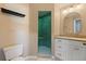 Well lit bathroom with green tiled shower and white vanity with gold hardware at 1206 Gulf Blvd # C, Indian Rocks Beach, FL 33785