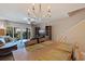 Open dining and living area featuring wood table, chandelier, staircase, and access to balcony at 1206 Gulf Blvd # C, Indian Rocks Beach, FL 33785
